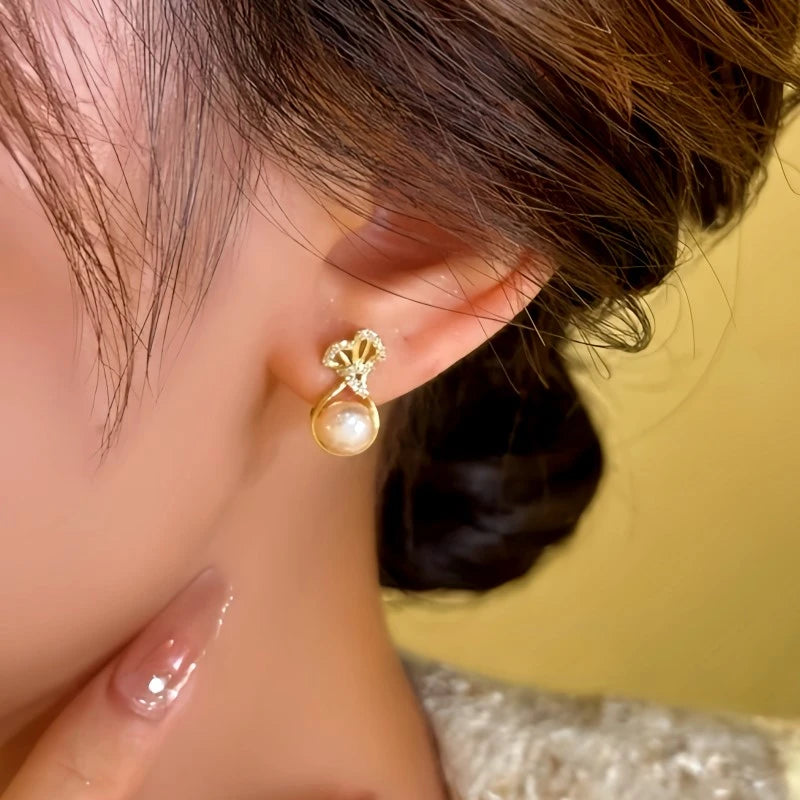 Model showcasing the dangle and style of the 14K Gold-Plated Lucky Bag Pearl Earrings
