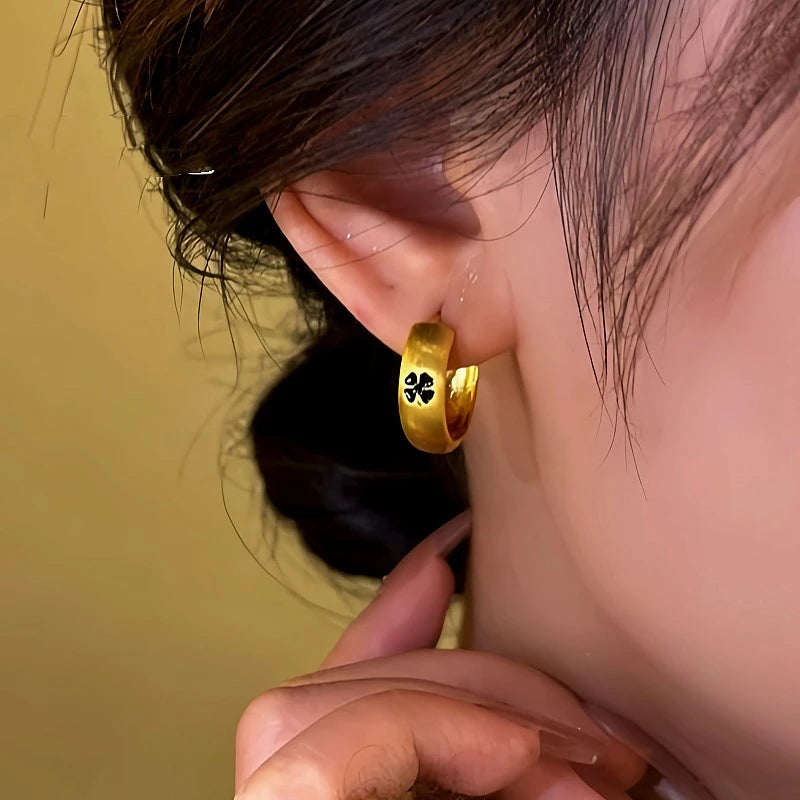 Close-up detail of the sparkling zircons and plating on the Clover Huggie Hoops