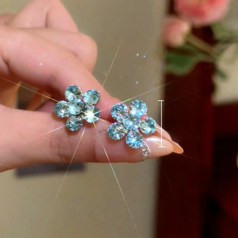 Model showcasing the dangle and style of the 14K Gold-Plated Luxury Blue Crystal Flower Stud Earrings