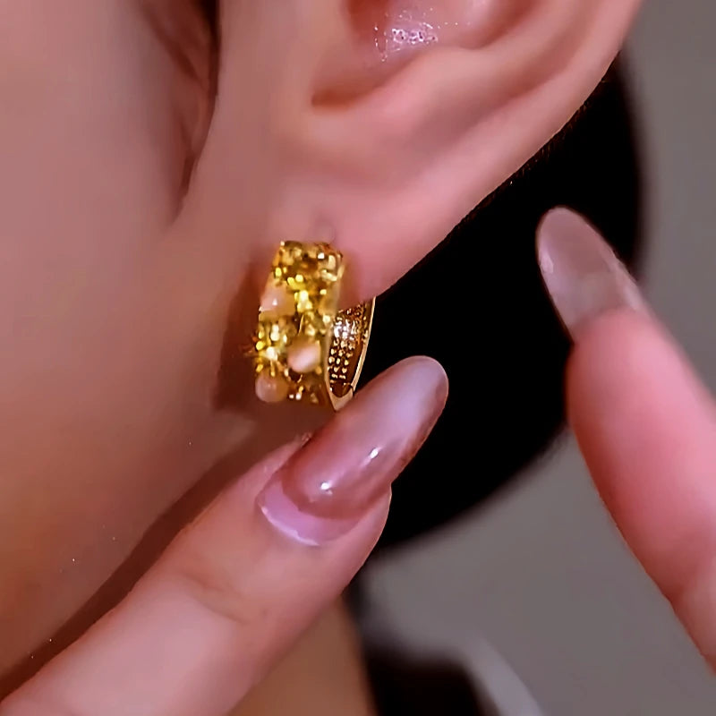 Model showcasing the dangle and style of the 14K Gold-Plated Luxury Brown Zircon Cat's Eye Hoop Earrings