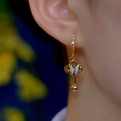 Model showcasing the dangle and style of the 14K Gold-Plated Luxury Brown Zircon Crystal Butterfly Earrings