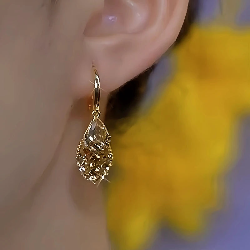 Model showcasing the dangle and style of the 14K Gold-Plated Luxury Brown Zircon Diamond Earrings