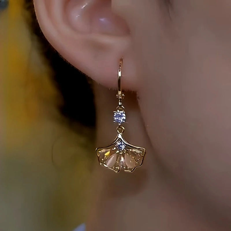 Model showcasing the dangle and style of the 14K Gold-Plated Luxury Brown Zircon Ginkgo Leaf Earrings