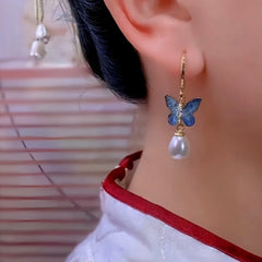 Model showcasing the dangle and style of the 14K Gold-Plated Luxury Butterfly Pearl Tassel Earrings
