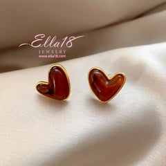 Model showcasing the dangle and style of the 14K Gold-Plated Luxury Cat's Eye Brown Heart Stud Earrings