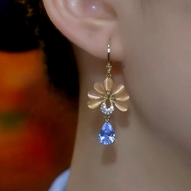 Model showcasing the dangle and style of the 14K Gold-Plated Luxury Cat's Eye Stone Flower Earrings