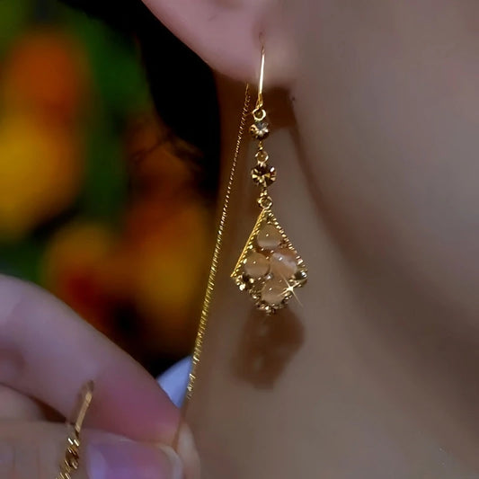 Model showcasing the dangle and style of the 14K Gold-Plated Luxury Cat's Eye Zircon Threader Earrings