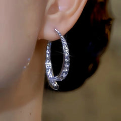 Model showcasing the dangle and style of the 14K Gold-Plated Luxury Cross Fishtail Earrings