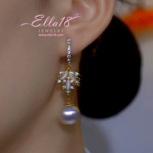 Model showcasing the dangle and style of the 14K Gold-Plated Luxury Design Zircon Diamond Cat's Eye Stone Pearl Earrings