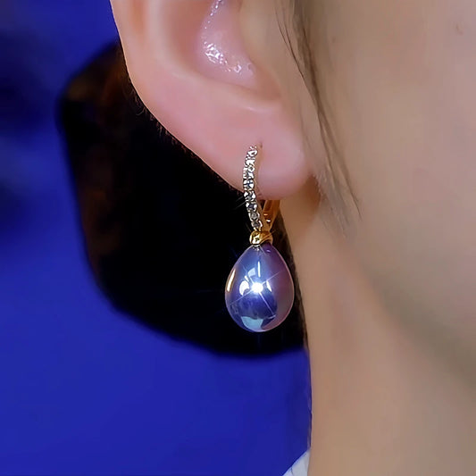Model showcasing the dangle and style of the 14K Gold-Plated Luxury Diamond-Encrusted Purple Pearl Earrings