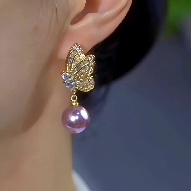 Model showcasing the dangle and style of the 14K Gold-Plated Luxury Diamond Butterfly Purple Pearl Earrings