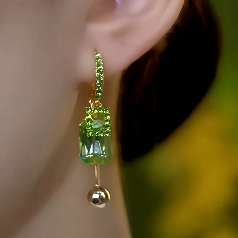 Model showcasing the dangle and style of the 14K Gold-Plated Luxury Green Zircon Diamond Tassel Earrings