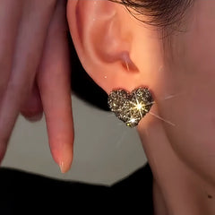 Model showcasing the dangle and style of the 14K Gold-Plated Luxury Grey Diamond Heart Stud Earrings
