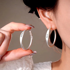 Model showcasing the dangle and style of the 14K Gold-Plated Luxury Letter Big Hoop Earrings