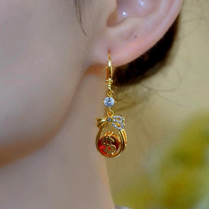 Model showcasing the dangle and style of the 14K Gold-Plated Luxury Lucky Rich Bag Earrings