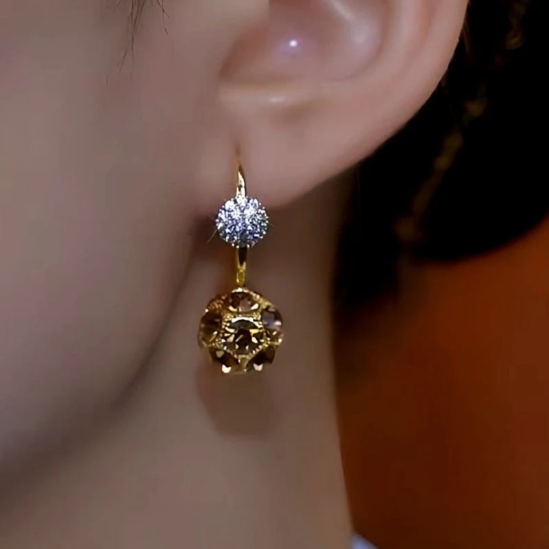 Model showcasing the dangle and style of the 14K Gold-Plated Luxury Maillard Coffee Color Diamond Ball Earrings