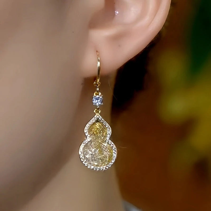 Model showcasing the dangle and style of the 14K Gold-Plated Luxury Mesh Gourd Earrings