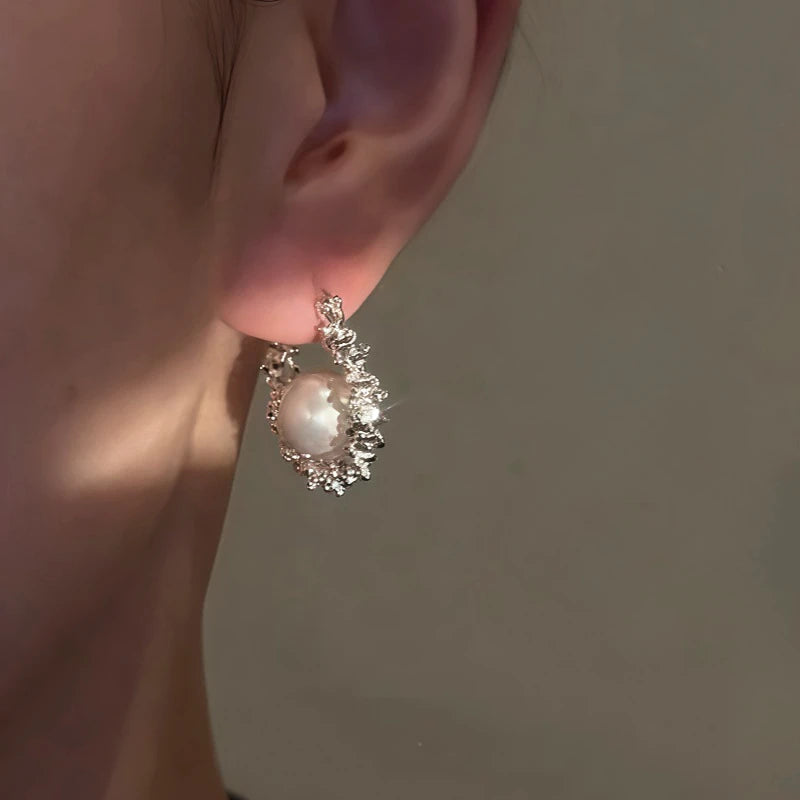 Model showcasing the dangle and style of the 14K Gold-Plated Luxury Pearl Hoop Earrings