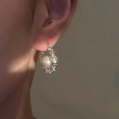 Model showcasing the dangle and style of the 14K Gold-Plated Luxury Pearl Hoop Earrings