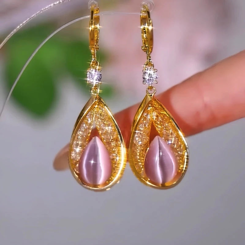 Model showcasing the dangle and style of the 14K Gold-Plated Luxury Pink Cat's Eye Stone Water Drop Earrings