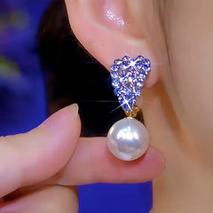 Model showcasing the dangle and style of the 14K Gold-Plated Luxury Purple Erystal Heart Pearl Earrings