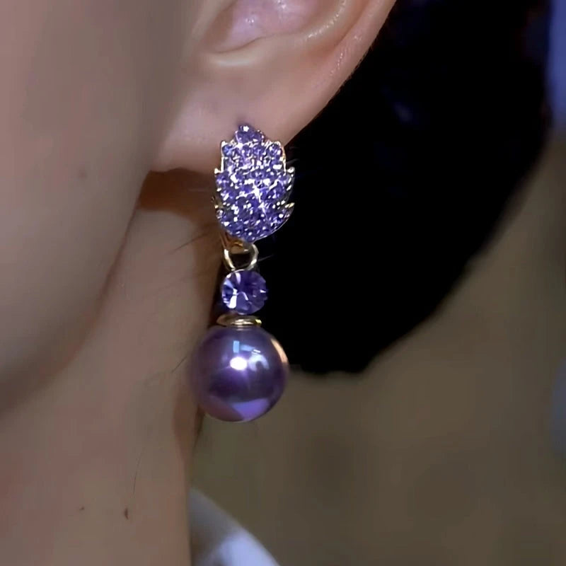 Model showcasing the dangle and style of the 14K Gold-Plated Luxury Purple Full Diamond Leaf Pearl Earrings