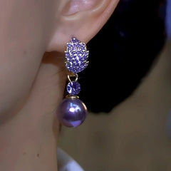 Model showcasing the dangle and style of the 14K Gold-Plated Luxury Purple Full Diamond Leaf Pearl Earrings