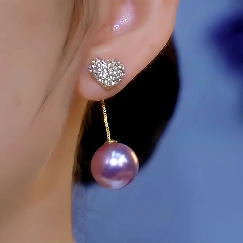 Model showcasing the dangle and style of the 14K Gold-Plated Luxury Purple Pearl Diamond Heart Earrings