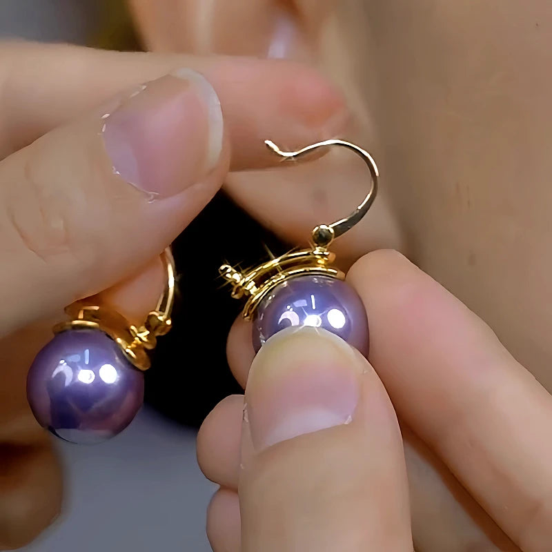 Model showcasing the dangle and style of the 14K Gold-Plated Luxury Purple Pearl Earrings