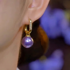 Model showcasing the dangle and style of the 14K Gold-Plated Luxury Purple Pearl Earrings