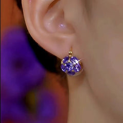 Model showcasing the dangle and style of the 14K Gold-Plated Luxury Purple Zircon Ball Earrings