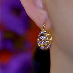 Model showcasing the dangle and style of the 14K Gold-Plated Luxury Purple Zircon Earrings