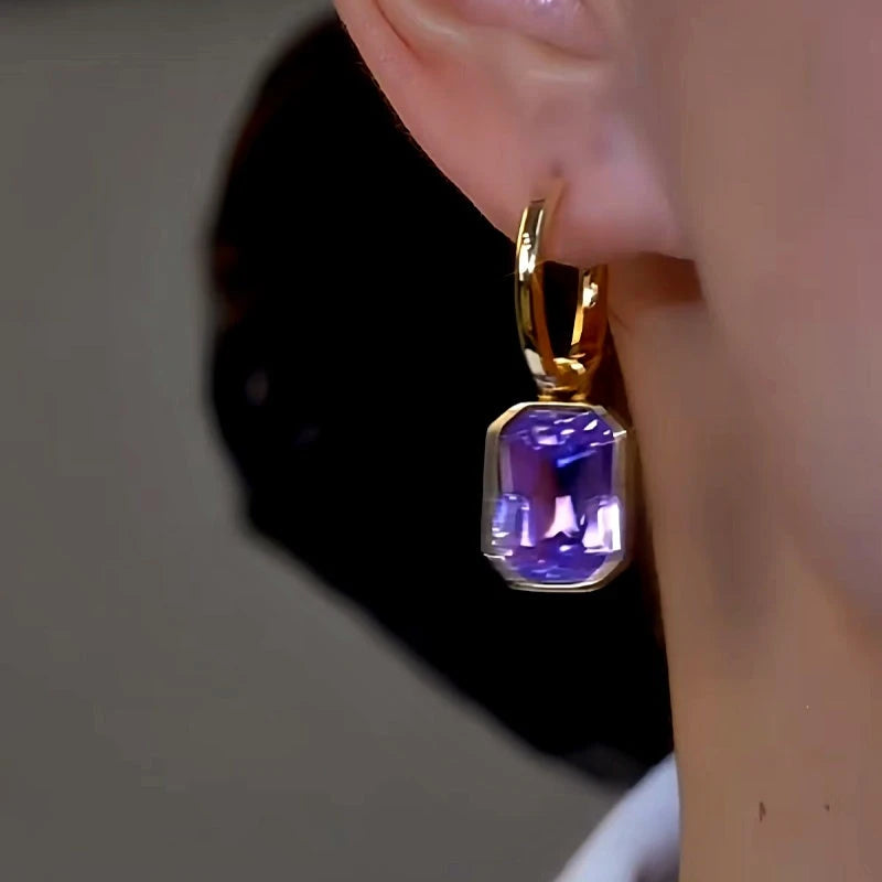 Model showcasing the dangle and style of the 14K Gold-Plated Luxury Purple Zircon Earrings