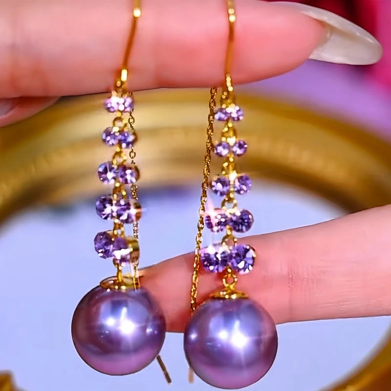 Angled view of the 14K Gold-Plated Luxury Purple Zircon Pearl Threader Tassel Earrings
