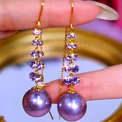 Angled view of the 14K Gold-Plated Luxury Purple Zircon Pearl Threader Tassel Earrings
