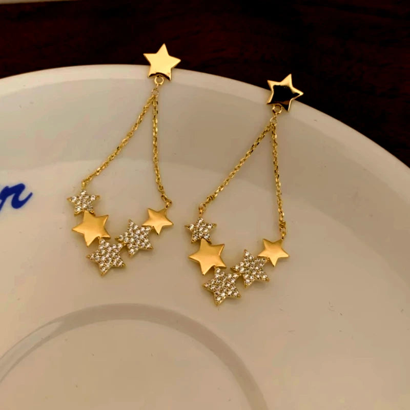 Angled view of the 14K Gold-Plated Luxury Star Tassel Earrings