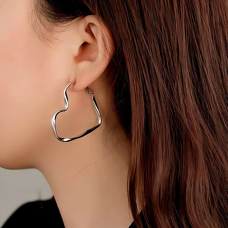 Model showcasing the dangle and style of the 14K Gold-Plated Luxury Twisted Irregular Big Heart Earrings