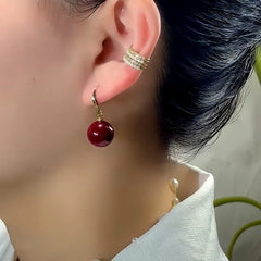 Model showcasing the dangle and style of the 14K Gold-Plated Luxury Wine Red Pearl Earrings