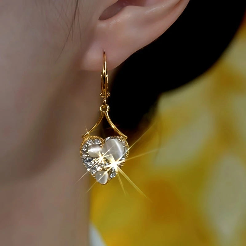 Model showcasing the dangle and style of the 14K Gold-Plated Luxury Zircon Cat's Eye Stone Heart Earrings