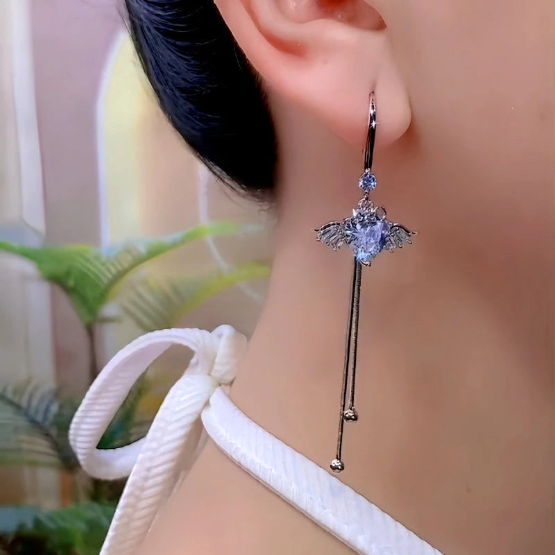 Model showcasing the dangle and style of the 14K Gold-Plated Luxury Zircon Diamond Heart Angel Wings Ear Hook Earrings