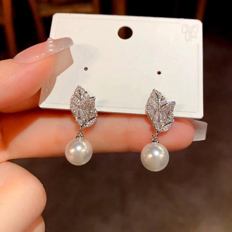 Angled view of the 14K Gold-Plated Luxury Zircon Diamond Leaf Pearl Earrings