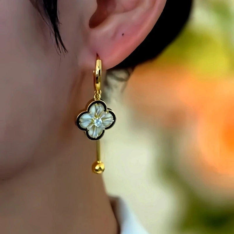 Model showcasing the dangle and style of the 14K Gold-Plated Luxury Zircon Four-Leaf Clover Tassel Earrings