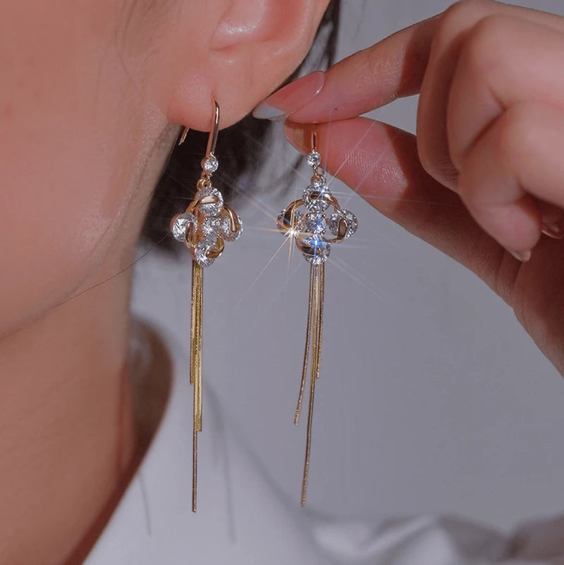 Model showcasing the dangle and style of the 14K Gold-Plated Luxury Zircon Four-Leaf Flower Ear Hook Tassel Earrings