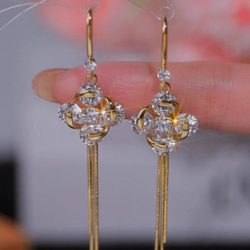 Angled view of the 14K Gold-Plated Luxury Zircon Four-Leaf Flower Ear Hook Tassel Earrings