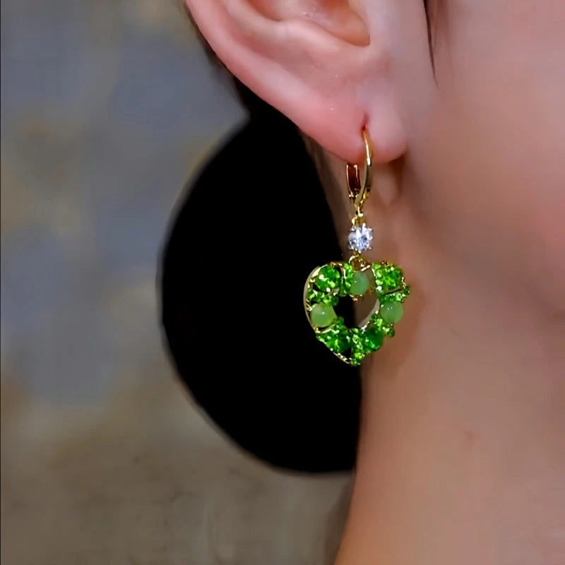 Model showcasing the dangle and style of the 14K Gold-Plated Luxury Zircon Green Diamond Cat's Eye Stone Heart Earrings