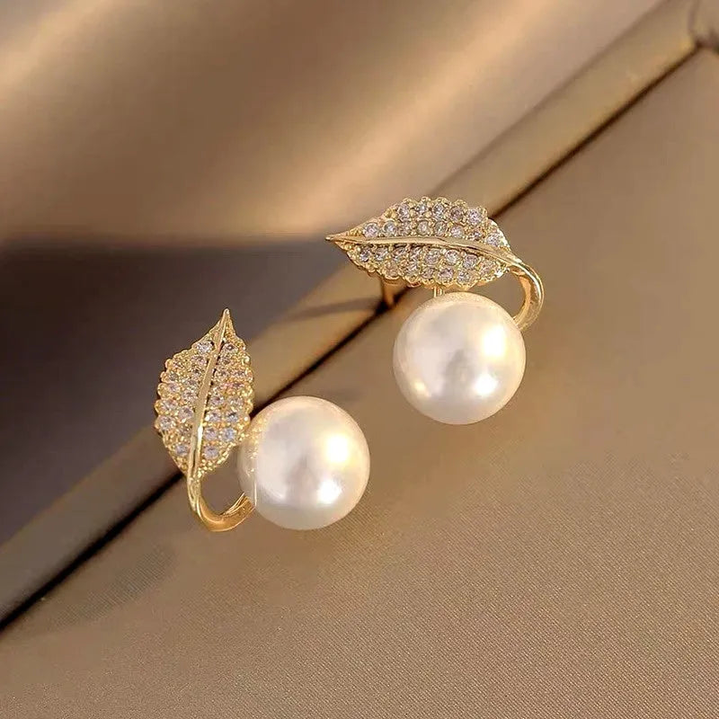 Model showcasing the dangle and style of the 14K Gold-Plated Luxury Zircon Leaf Pearl Stud Earrings