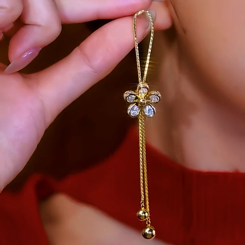 Angled view of the 14K Gold-Plated Luxury Zircon Moving Adjustable Flower Tassel Earrings