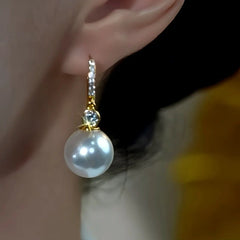 Model showcasing the dangle and style of the 14K Gold-Plated Luxury Zircon Pearl Earrings