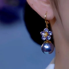 Model showcasing the dangle and style of the 14K Gold-Plated Luxury Zircon Petal Flower Purple Pearl Earrings