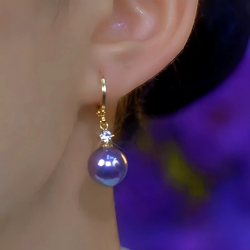Model showcasing the dangle and style of the 14K Gold-Plated Luxury Zircon Purple Pearl Earrings